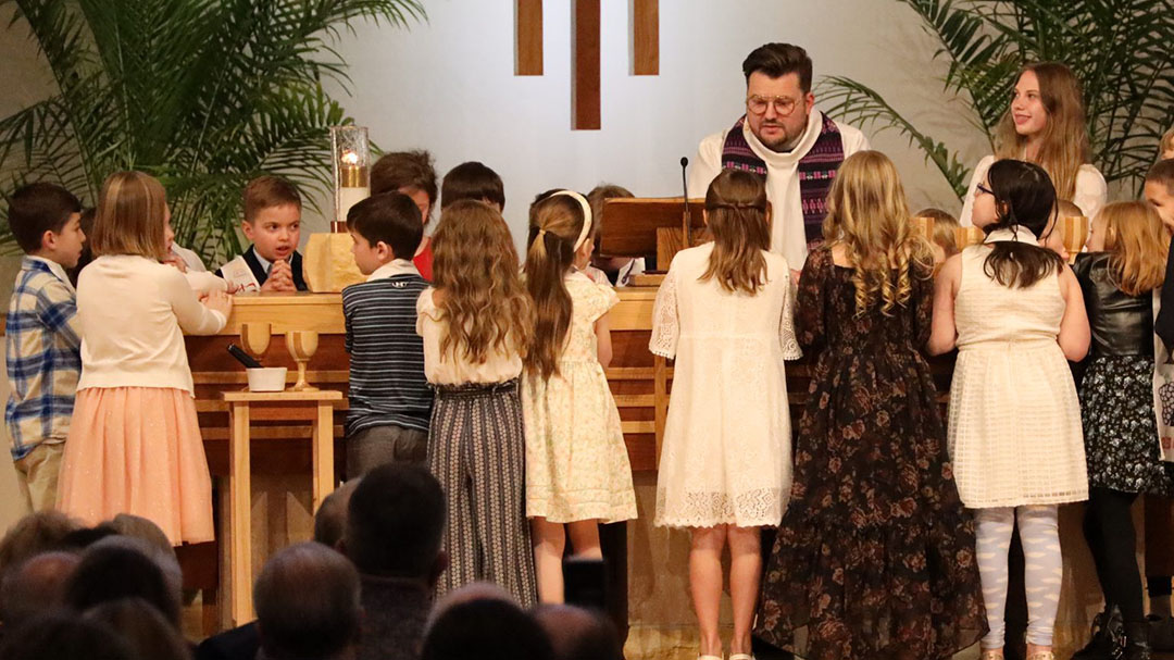 Pastor praying at church with children
