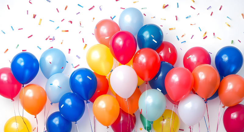 Multi-colored balloons with confetti in the background